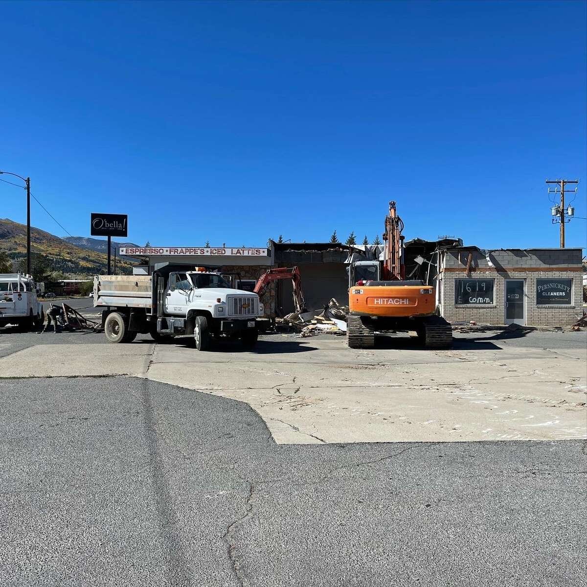 Handy's Construction excavator and dump truck demolishing an old commercial building