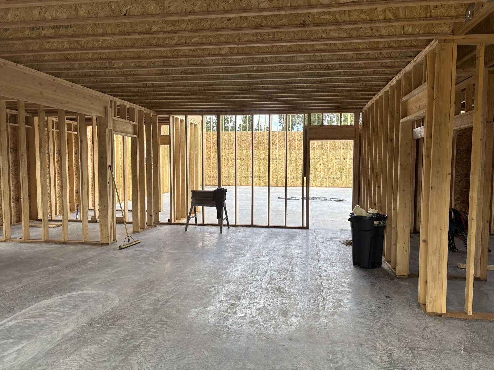 Framed stud walls standing on a finished concrete slab inside a new building